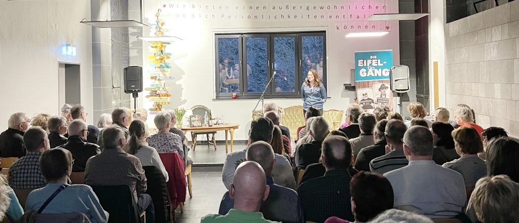 Geschäftsführerin Maile Seidenfaden begrüßte das ausverkaufte Haus und bedankte sich bei der „Eifel-Gäng“ und allen bislang in der Reihe „Kunst, Kultur und Vielfalt“ in der Kulturkapelle aufgetretenen und dieses Jahr auftretenden Künstlern, darunter Nicole Wollenweber und ihren Männern, Stephan Brings, Uwe Reetz und Ex-Höhner-Bassist Hannes Schöner mit Ady Zehnpfennig und Hermann Heuser. Foto: Thomas Hochgürtel/pp/Agentur ProfiPress